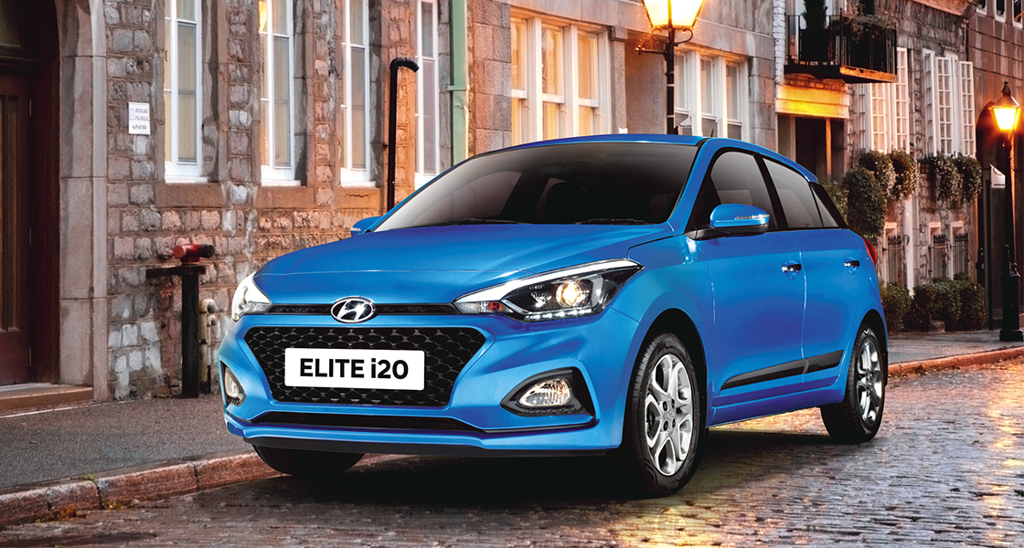 Right side rear view of driving red Elite i20 on the road