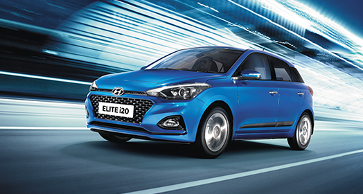 Right side rear view of driving red Elite i20 on the road