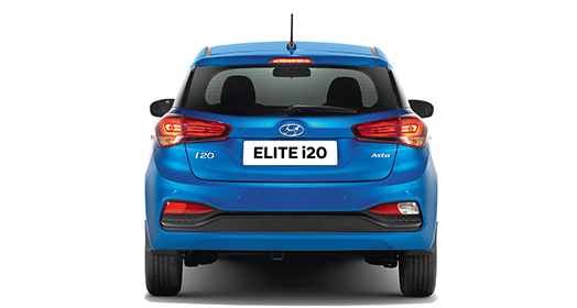 Side view of red Elite i20 driving out from the car garage