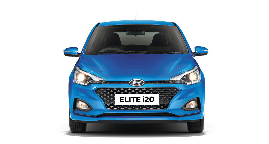 Side view of red Elite i20 driving fast on the road in the city