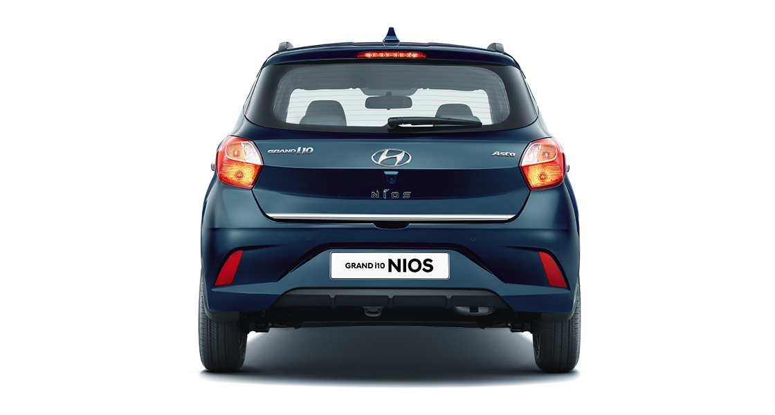 Side front view of orange Grandi10 with skyline view