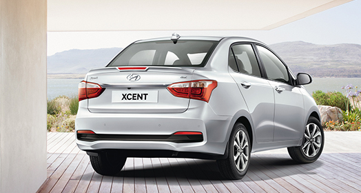 Right side rear view of silver Xcent parked on the road
